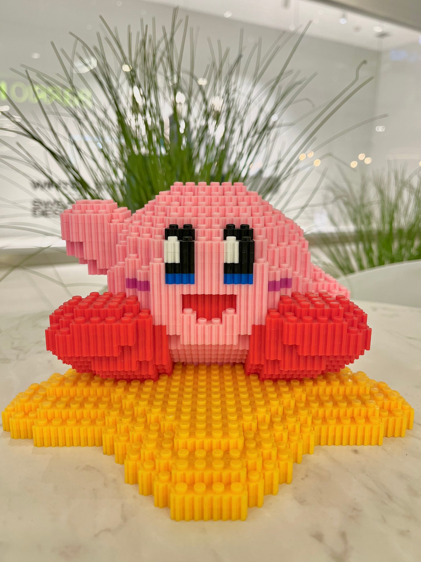 Figura pixel armable de Kirby sobre estrella de Kirby