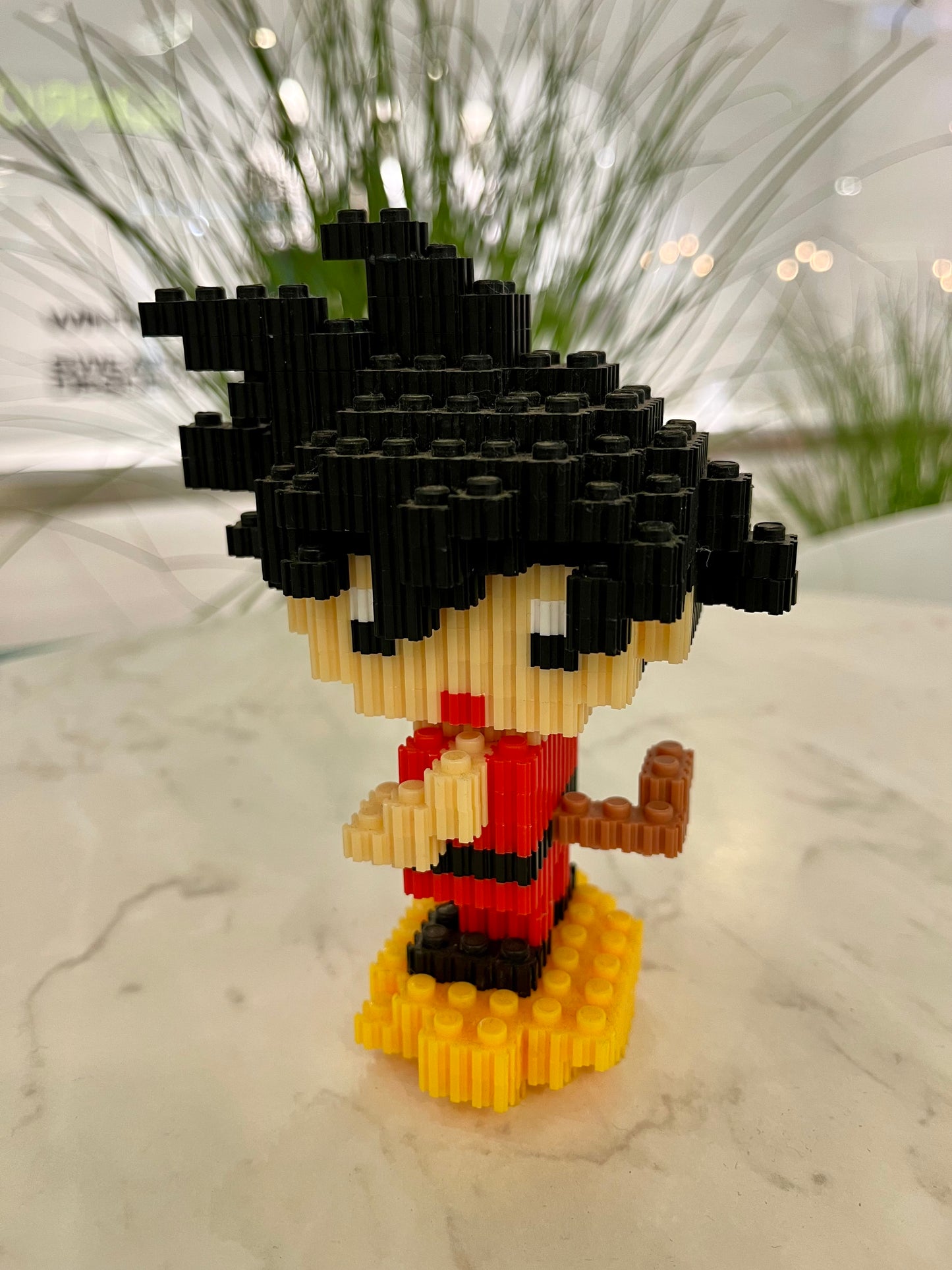 Figura pixel armable de Goku sobre la nube voladora de Dragon Ball