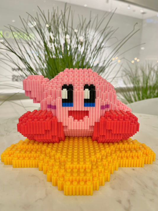 Figura pixel armable de Kirby sobre estrella de Kirby